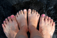Adventurers' feet on Black Sand Beach